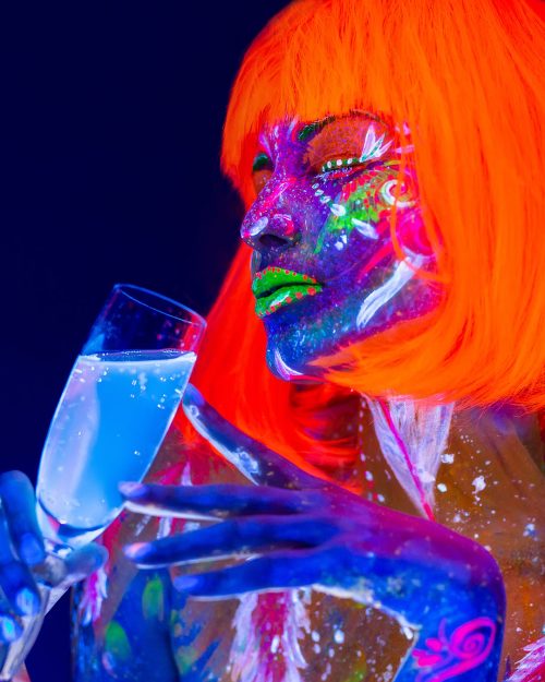 woman-drinking-champagne-in-neon-light-disco-nigh-2022-02-18-05-29-14-utc